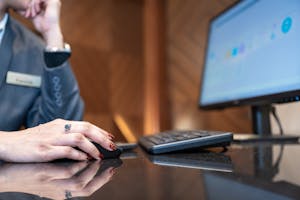 Close-up of a business professional using a computer mouse and keyboard in a modern office environment.