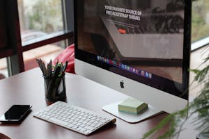 A clean, organized desk setup featuring a computer display, keyboard, and office supplies.